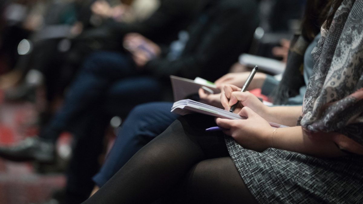 Image of woman taking notes at an event or conference